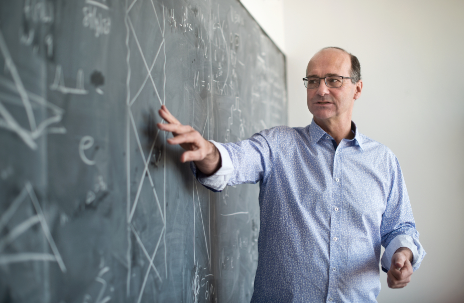Perimeter Institute's new director, Robert Meyer, in front of a blackboard with equations