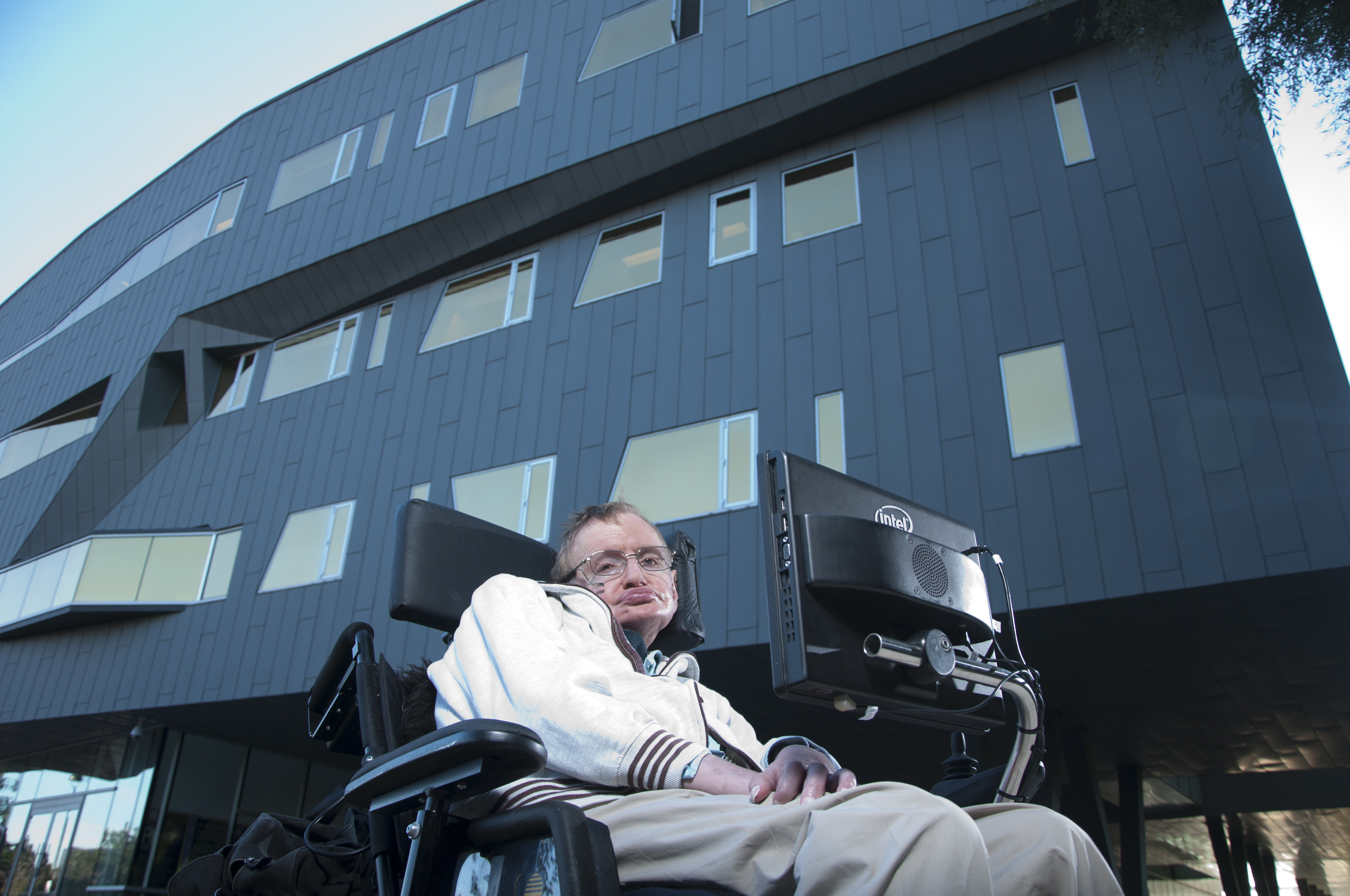 Stephen Hawking posing in front of the Stephen Hawking centre building at Perimeter Institue