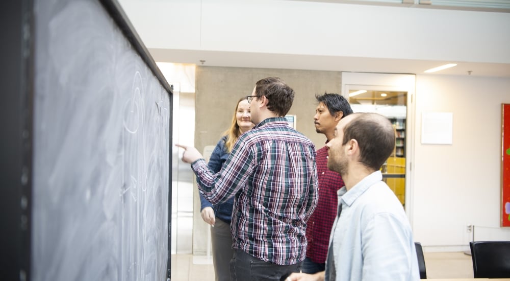 Bianca Dittrich, Aldo Riello, Etera Livine, and Christophe Goeller working at a blackboard