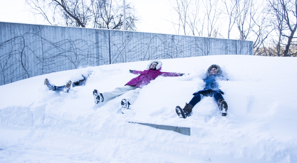 students making snow angels in front of the Perimeter Institute building