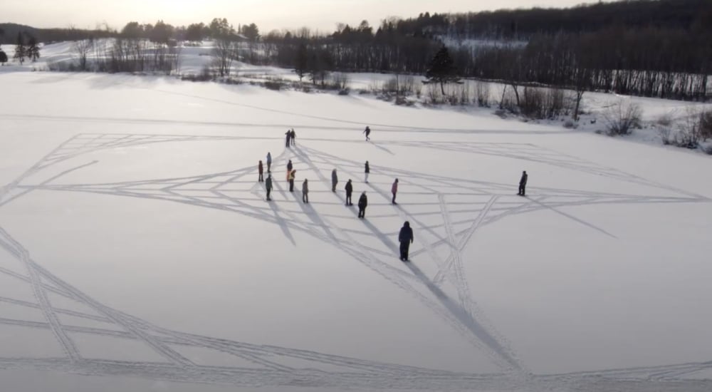 Students making symbols in a field of snow