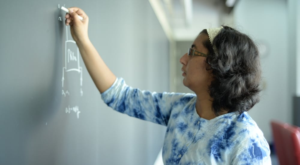 Nitica-Sakharwade working at a blackboard