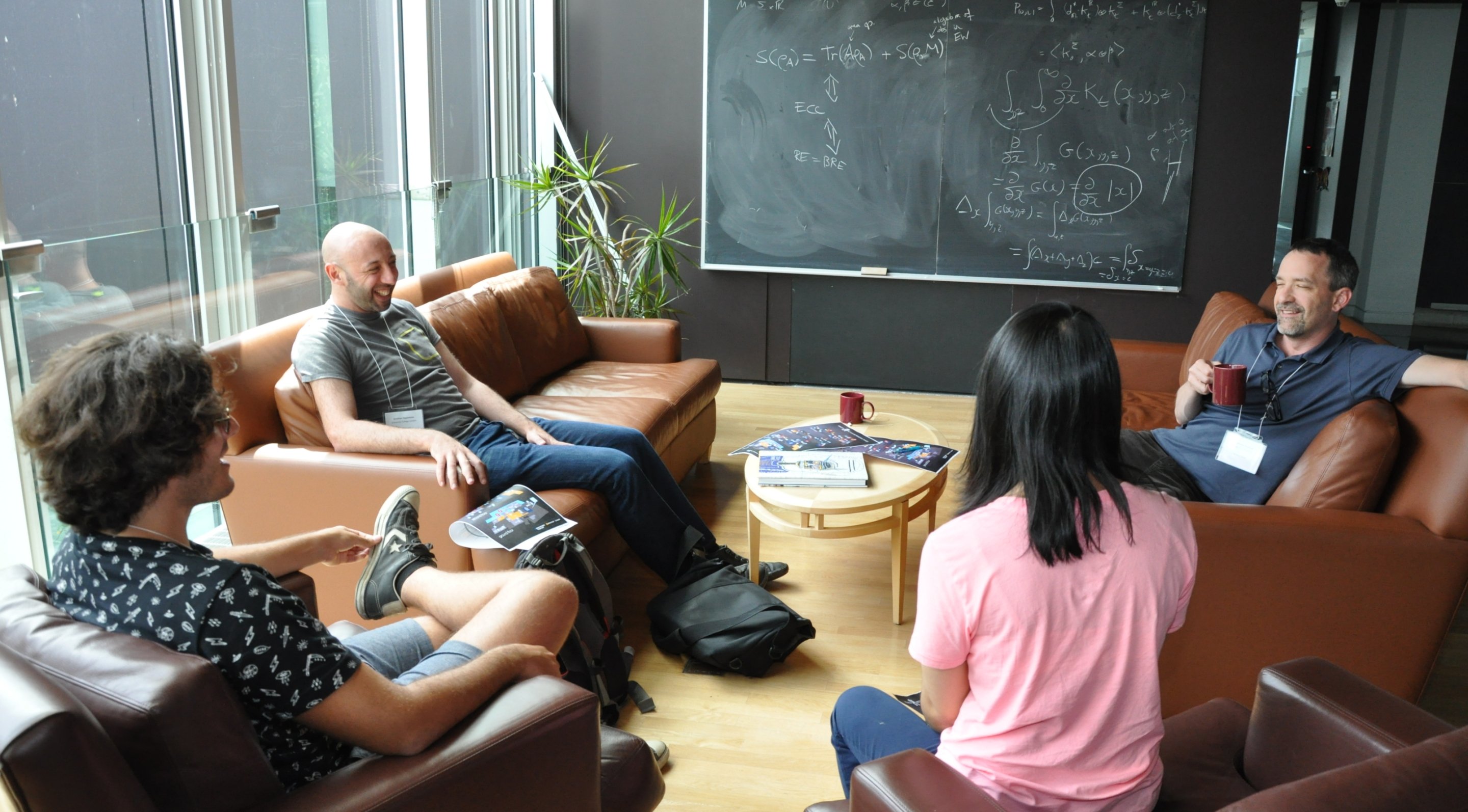 Group of researchers collaborating together in front of a blackboard