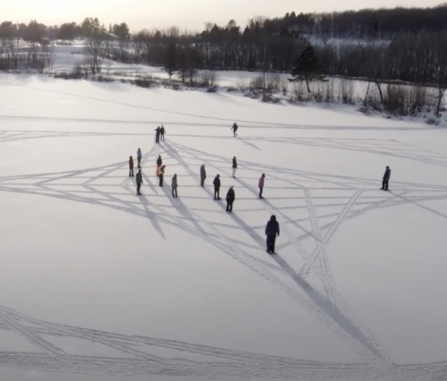 Students making symbols in a field of snow