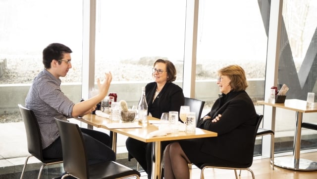 Two women and man talking over lunch