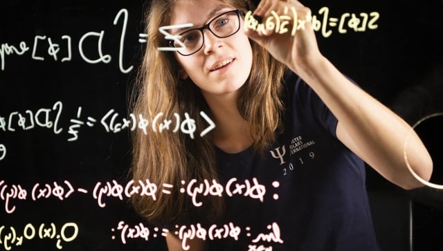 researcher writing equations on a transparent window