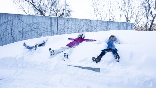 students making snow angels in front of the Perimeter Institute building