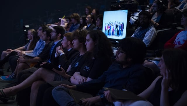 Group of students in a theatre listening to a presentation