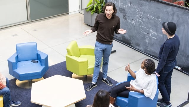 Students talking in a group around a chalkboard