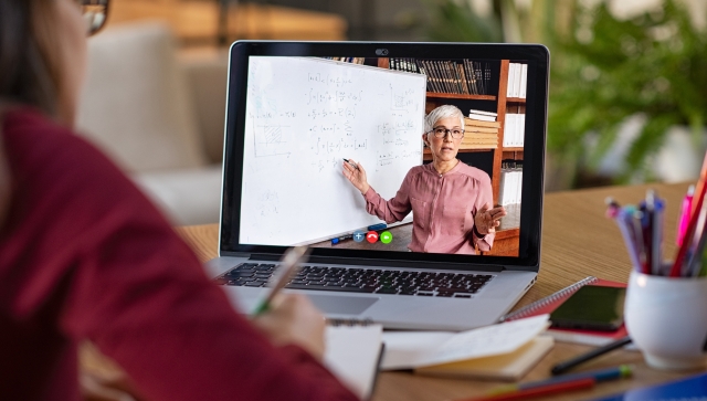 Woman doing a virtual class and teacher on computer screen teaching