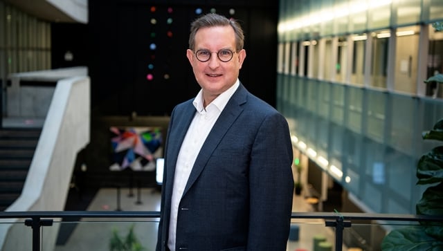 A man in a suit standing in an atrium