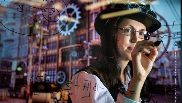 Woman wearing a hard hat and writing equations on a clear board with machinery behind her