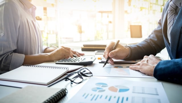 Woman and man sitting at table together working on financial statements