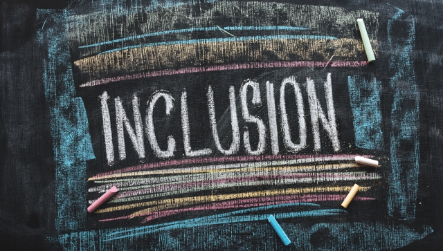 Chalkboard drawing of the word Inclusion with coloured chalk lines around it