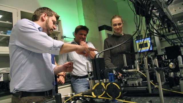 A group of researchers working together in a lab on an experiment