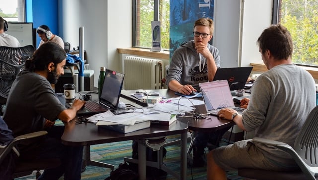 Group of men working together at a table with their computers