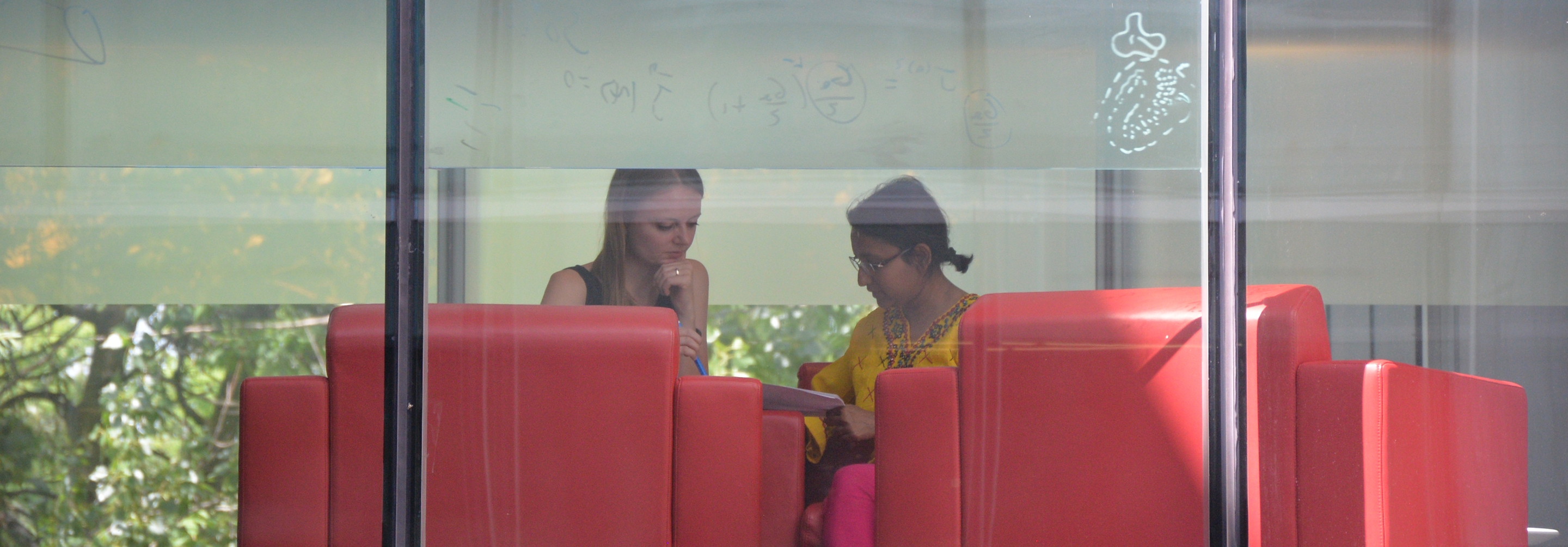 Looking through a window to see two women sitting together having a discussion