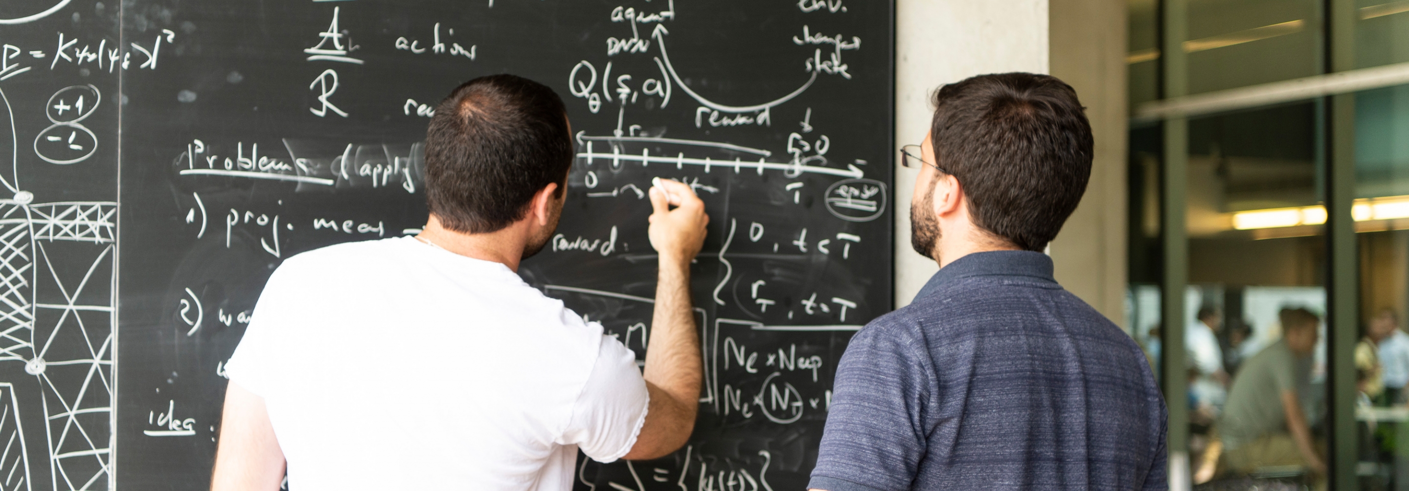 Two men working together on a blackboard