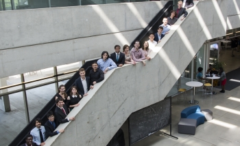 PSI class of 2017 posing in a row on the stairs of Perimeter Institute's atrium