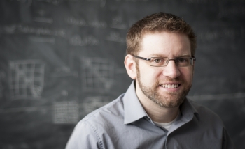 Portrait of Rob Spekkens in front of a blackboard