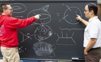 Oliver Schlotterer and Freddy Cachazo working at a blackboard