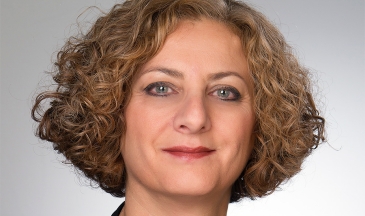 Portrait of a woman wearing a black blazer with short curly hair
