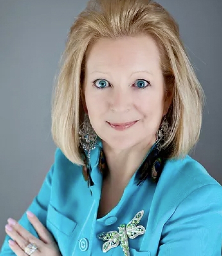 Portrait of a woman with blonde hair in a bright blue blazer